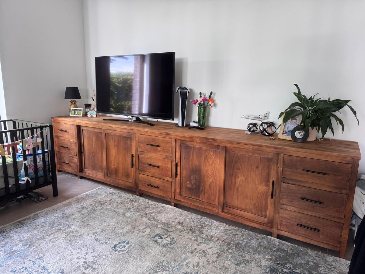 Teak dressoir van 3,80 meter met vier deuren en negen lades, als tv-meubel in een woonkamer in Lier